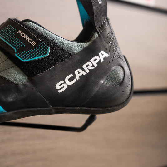 A close up of Scarpa Force heel, resting on black hook against metallic background.