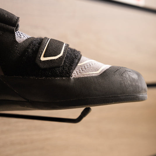 A close up Scarpa Reflex VS WMN toe box, resting on black wall hook against metallic background.