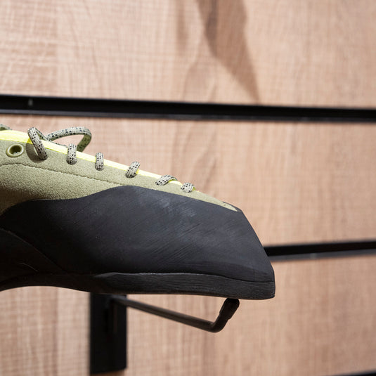 A close up Unparallel Beat toe box, resting on black wall hook against wooden background.