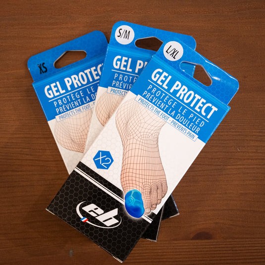 Three packs of EB Gel Toe protectors laid on top of one another on wooden surface