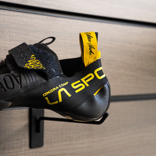 A close up of La Sportiva Ondra Comp heel, resting on black hook against metallic background.