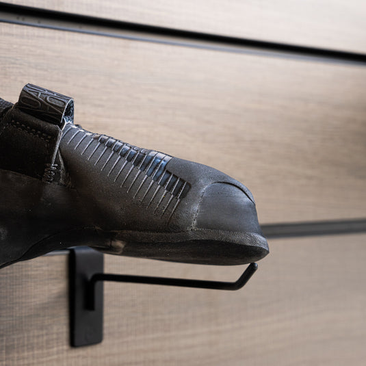 A close up La Sportiva Ondra Comp toe box, resting on black wall hook against metallic background.