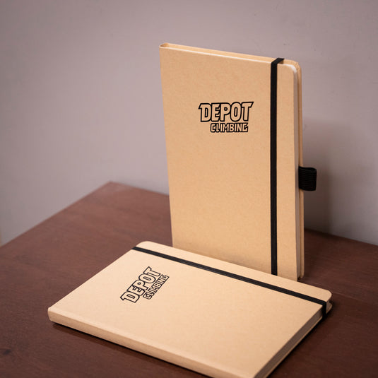 two A5 Depot Climbing Printed Note Books on wooden surface