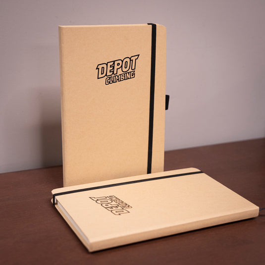 two A5 Depot Climbing Printed Note Books on wooden surface