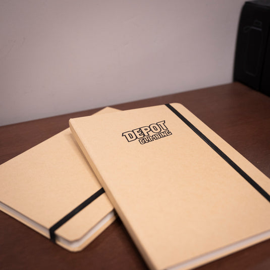 two A5 Depot Climbing Printed Note Books laid on wooden surface