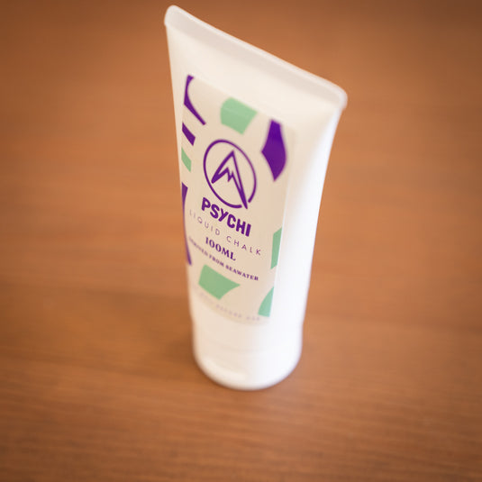 Side profile of Psychi Liquid chalk, 100ml tube labeled with purple and green design.