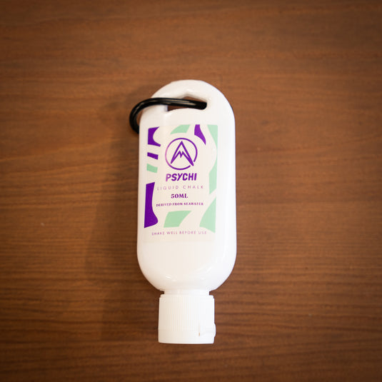 Front profile of Psychi Liquid chalk, 50ml tube with a black carabiner with purple and green designs.