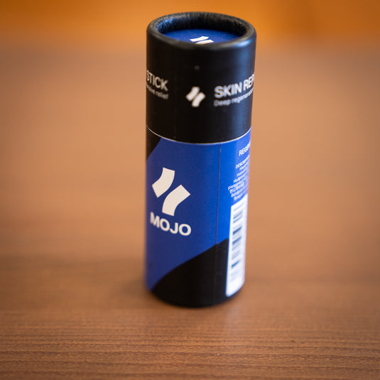 Close up of the Crux Mojo Repair Stick in black and blue cylindrical package.