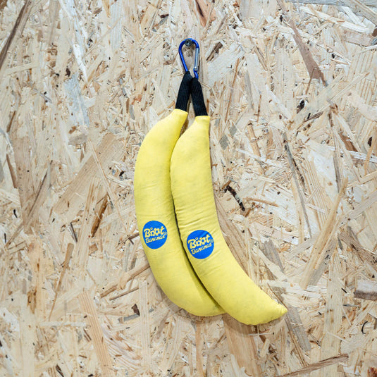 Two used yellow Boot bananas attached to blue carabiner hanging from hook