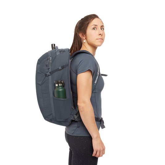 Rab Misfit 27L in Ebony on womans back with water bottle in side pocket