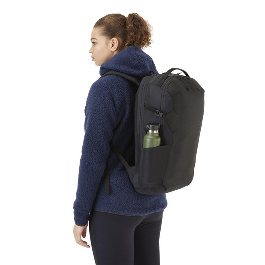 RAB Depot 22 Backpack on female's back with water bottle in side pocket