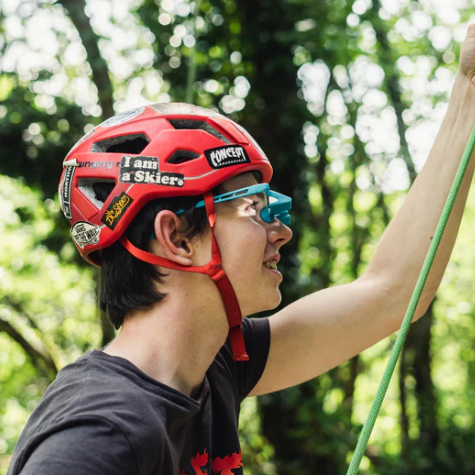 YY Plasfun EVO Belay Glasses in blue worn by belayer wearing red helmet,