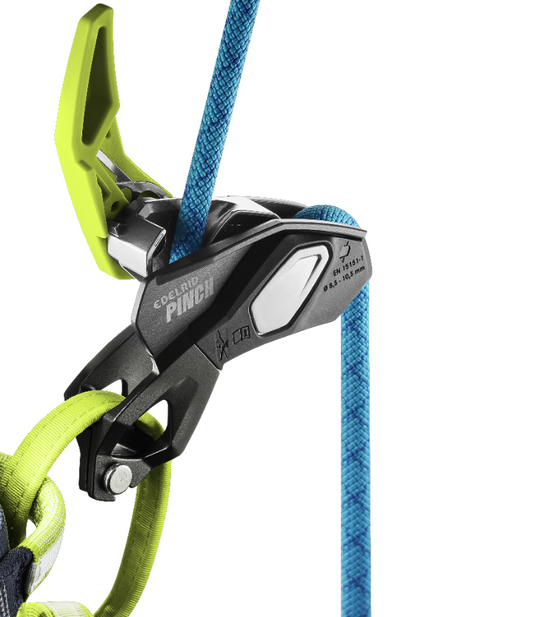 Edelrid Pinch Belay Device attached to harness with blue rope threaded through with green lever open