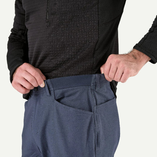 Patagonia Mens Venga Rock Pants in smoulder blue worn by model showing stretchy waistband