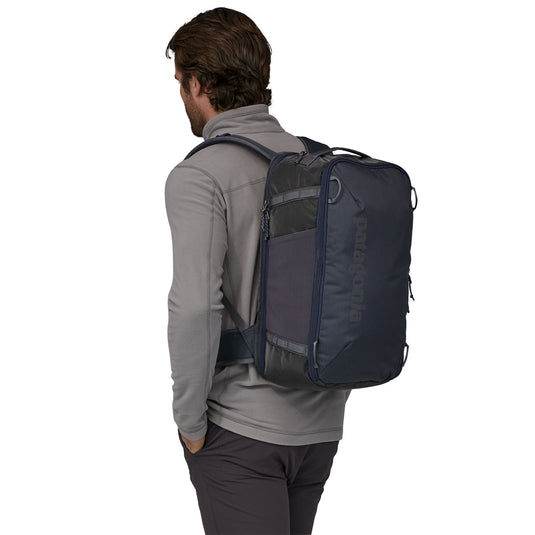 Patagonia Black Hole Mini MLC in smoulder blue - worn backpack style on model facing away