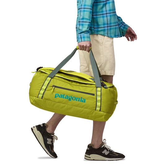 Patagonia Black Hole Duffel in Phosphorus green being held by hand straps