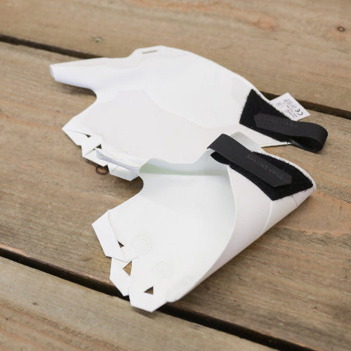 A pair of white crack climbing gloves with adjustable wrist straps laid on wooden surface