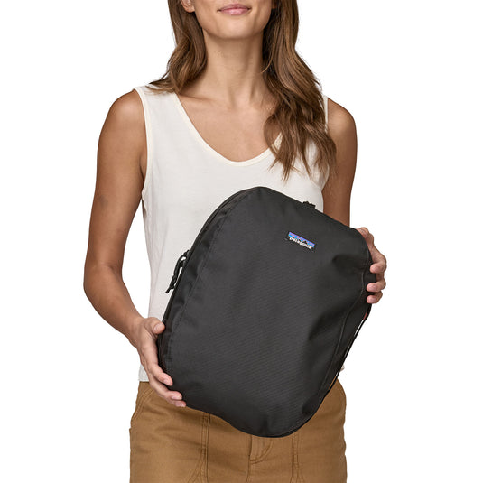 Patagonia Black Hole Cube 14L in black on black held by model