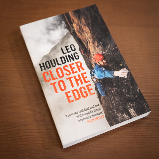 Leo Houlding - closer to the edge - featuring leo climbing above clouds on rockface on the cover - laid on wooden surface