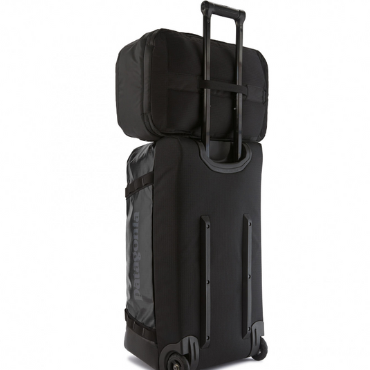 Patagonia Black Hole Mini MLC in black -on top of rolling luggage