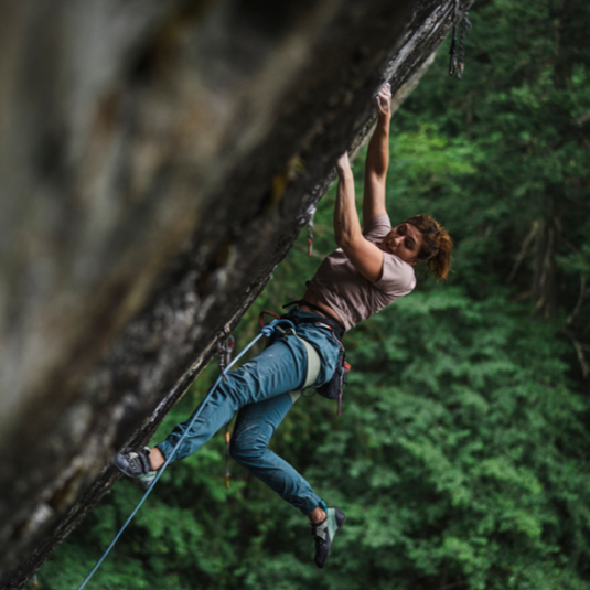 Climber on outdoor sport route wearing harness and black diamond notion pants. 