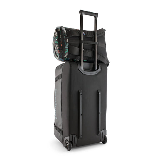Patagonia Black Hole Pack 25L in Kaleido Black on top of rolling luggage