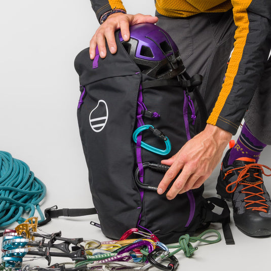 Wild Country Progress Backpack with carabiners attached and purple helmet packed 